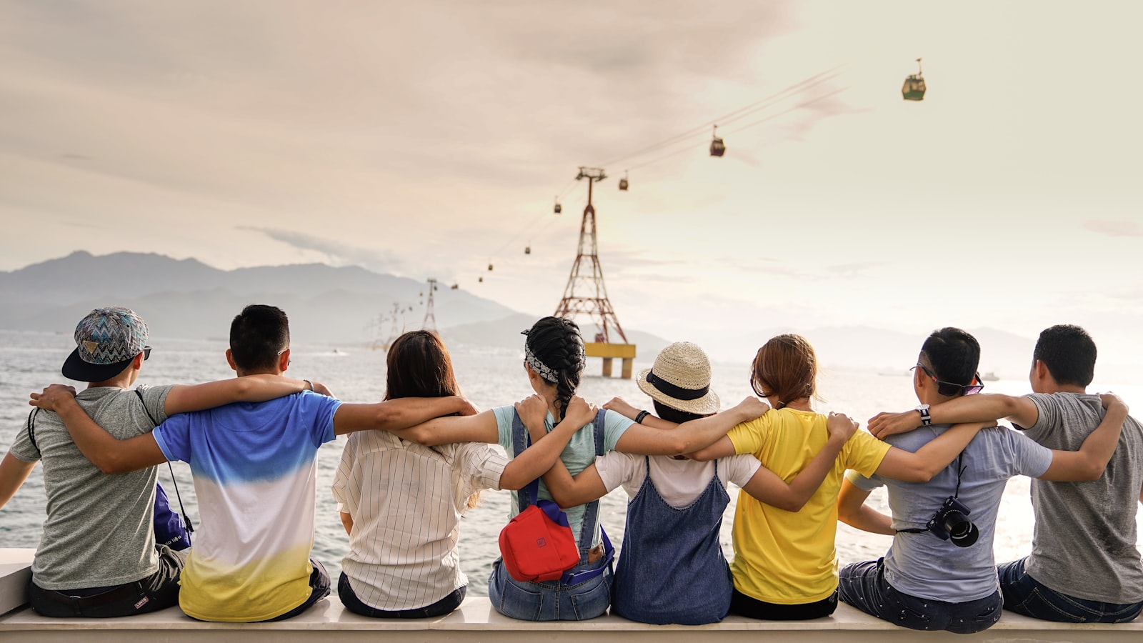 Friends with arms around each other at sunset